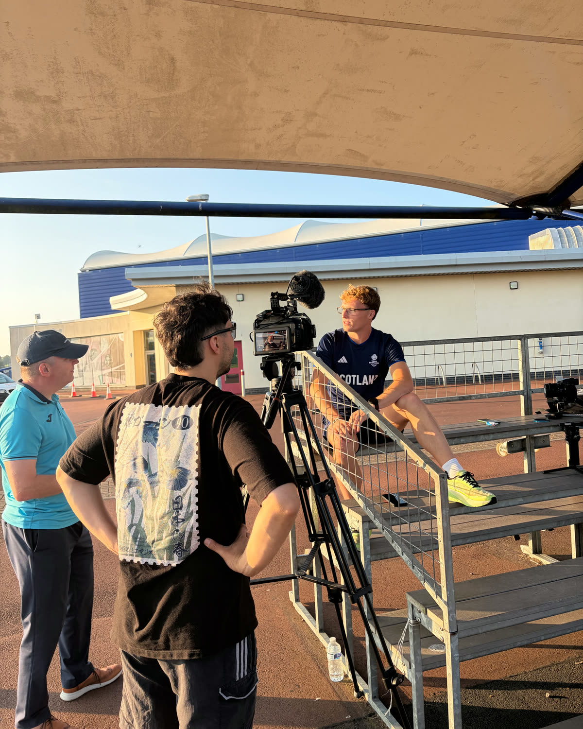 Behind the scenes filming an athlete interview trackside at golden hour